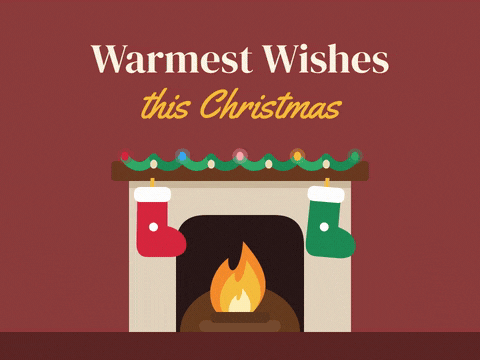 Warmest wishes this Christmas above a cozy fireplace with a flickering fire, two swaying stockings and a lit garland