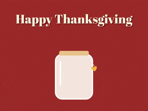 Happy Thanksgiving, thanks team in cut-out letter tiles as gratitude notes drop into a glass jar