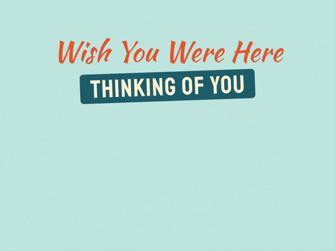 Wish you were here postcard with a sunny sea view and a heart stamp, thinking of you message