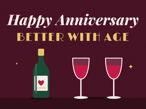 Happy anniversary, better with age message with a wine bottle and two red wine glasses clinking