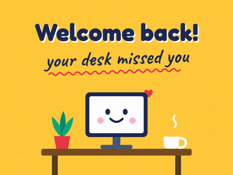 Welcome back, your desk missed you message with a smiling computer monitor hopping on an office desk