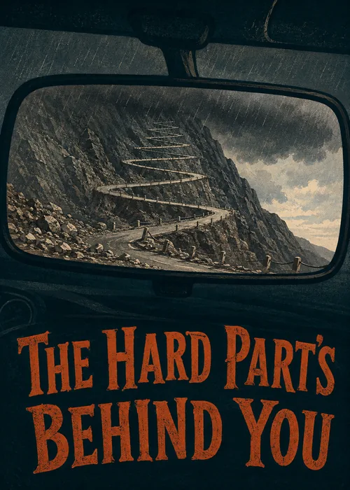 Winding mountain road reflected in a car rearview mirror beneath The Hard Parts Behind You text